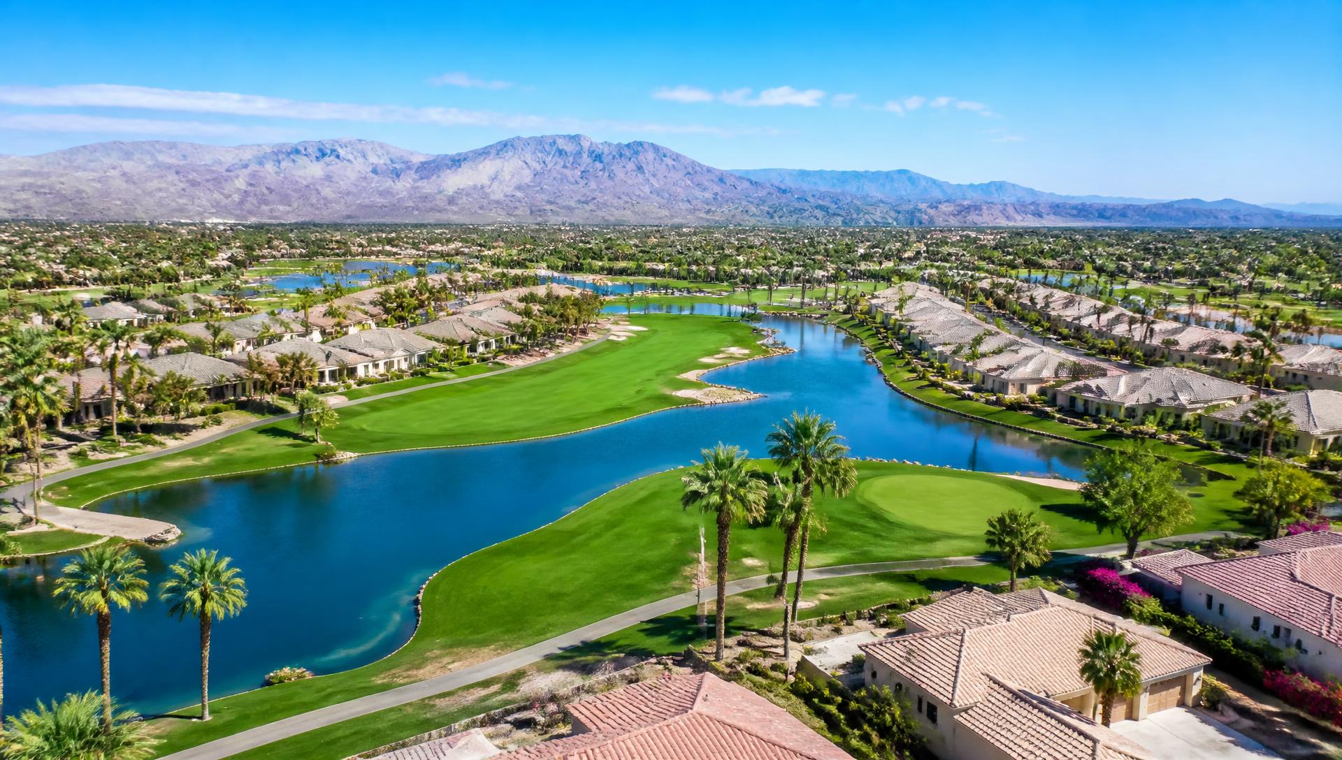 Aerial view of green fairways, blue lakes and tile-roof homes in Arizona's West Valley active adult communities